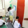 校舎の壁に絵を描く様子