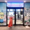 「Ponpoko & Peanuts Cafe」の前で写真を撮ってもらう筆者