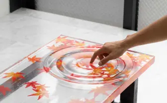 波紋、揺れてる? 錯覚するほど透明な紅葉のテーブル 制作に応用科学の知見を活用