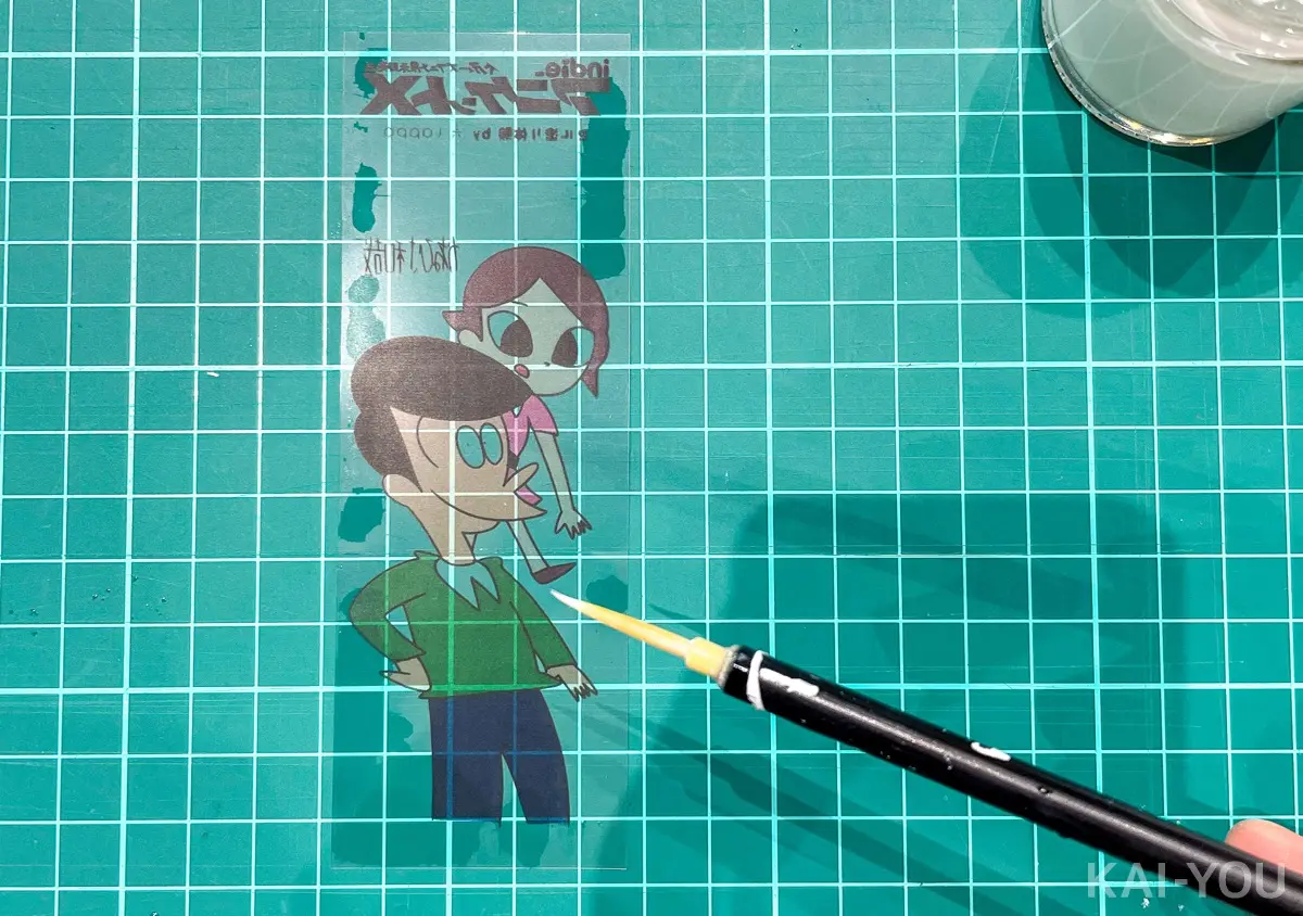 イラストが描かれた透明なセルの裏側に白絵の具を塗っていきます