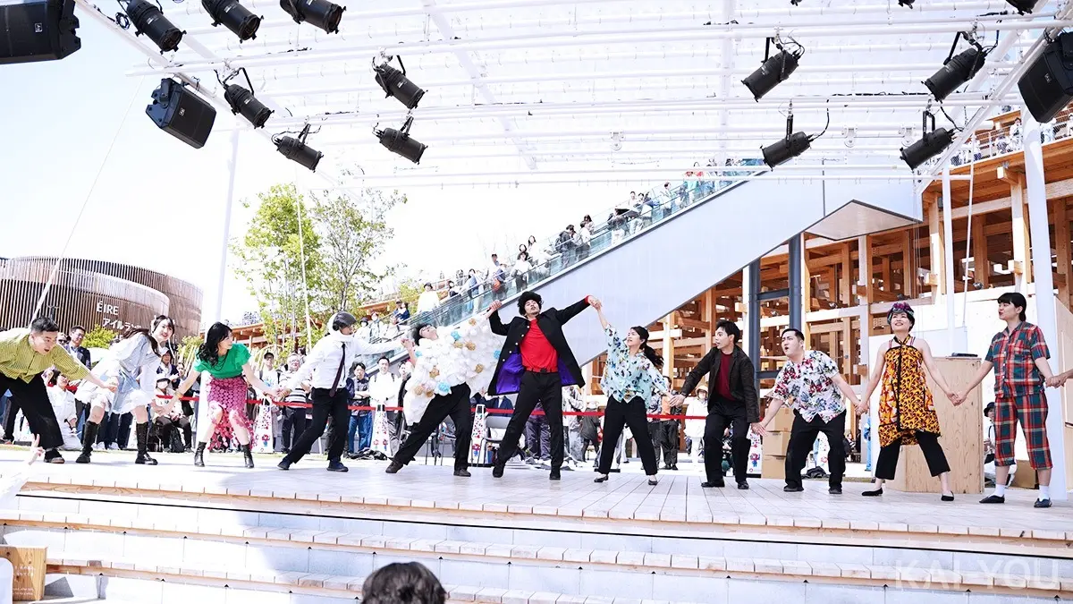 晴天の屋外会場で踊る12名の社員たち