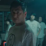 不気味なマークが描かれた揃いのTシャツを着用した集団／