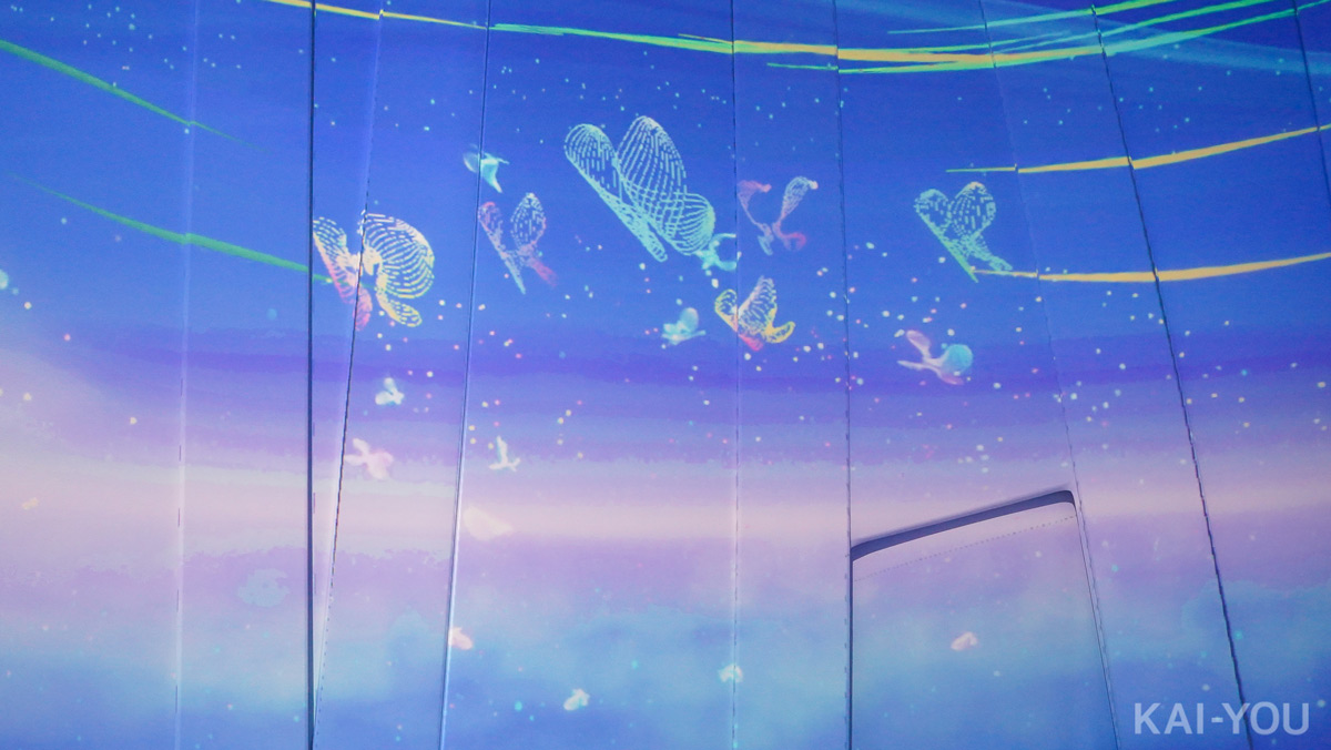 壁面に投影されるチョウを子どもたちが追いかけていました