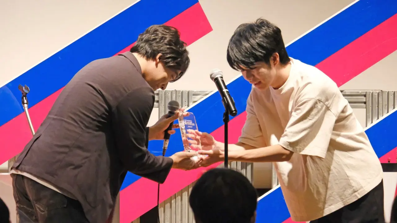 優勝トロフィーを有働英永さんに授与する伊沢拓司さん