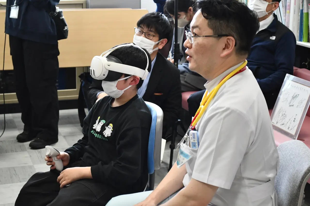 小児がん患者によるコンテンツ体験の様子（画像右：広島大学病院 佐伯教授）