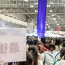 佐伯イッテツさんのパネル撮影待機列最後尾から。奥の紫色の垂れ幕の下にパネルが設置されている。