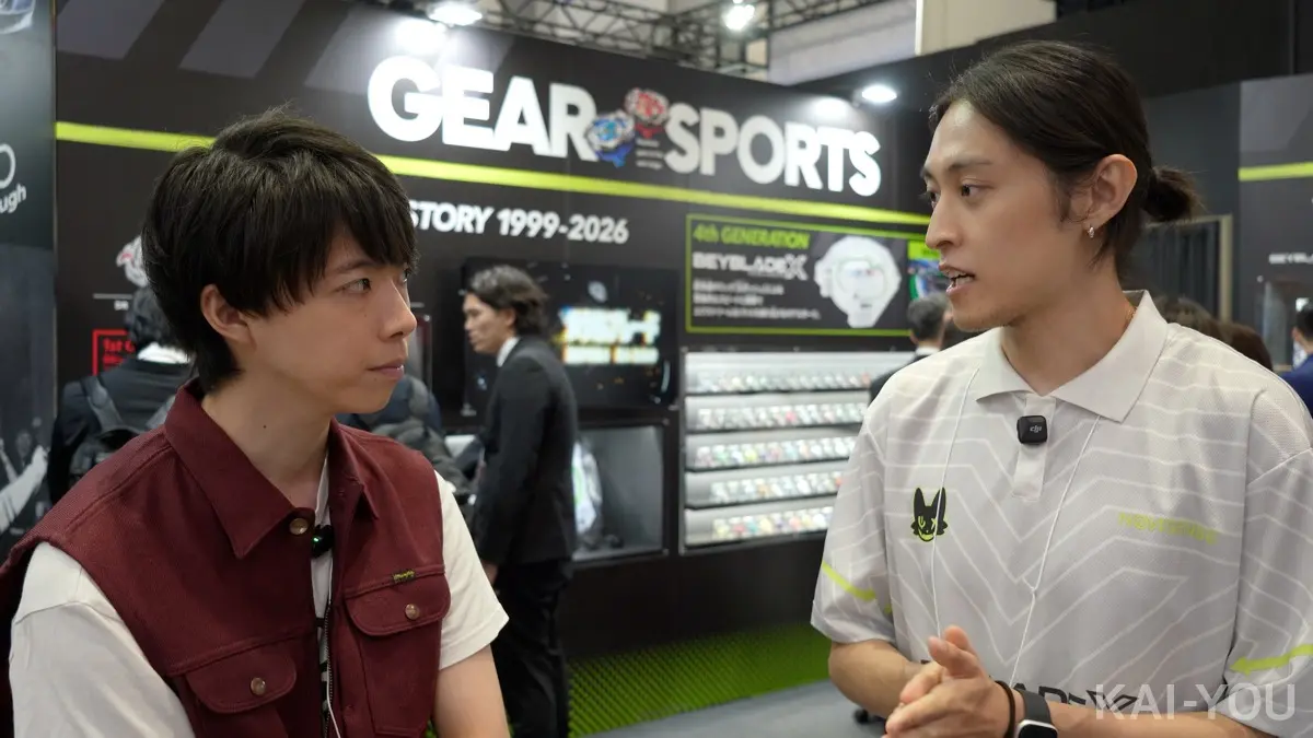 取材に応えるベイブレード開発チームの山本さん(右)
